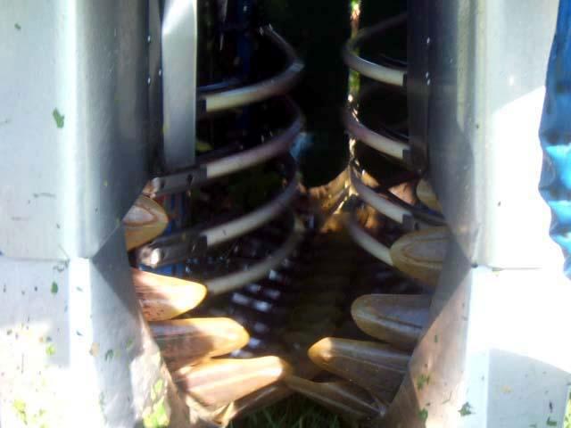 001 2.JPG - Les godets des norias, qui défilent en sens inverse de l'avancement de la machine, viennent se placer sous les pieds pour recevoir les raisins. Le mouvement oscillant des huit secoueurs permet de récolter l'intégralité des raisins.